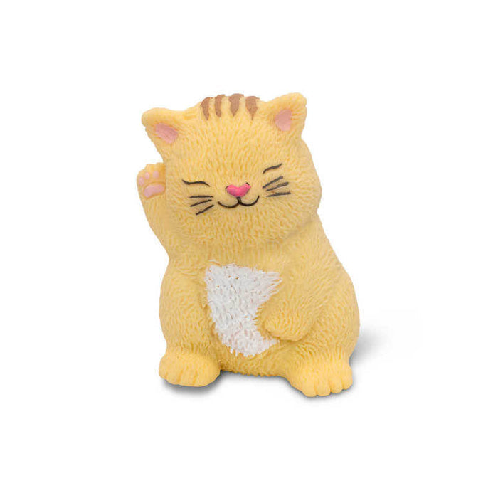 Textured yellow toy cat with a raised paw, closed eyes, pink ears and nose, and a white belly.