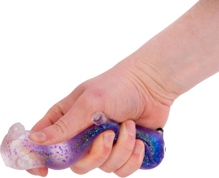 Hand gripping a long, purple translucent squishy toy filled with colorful glitter, shaped like a sausage dog.