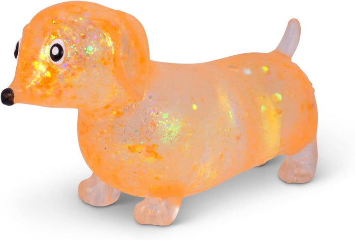 Translucent orange squishy sausage dog toy with internal glitter, black nose, googly eyes, and stubby legs.
