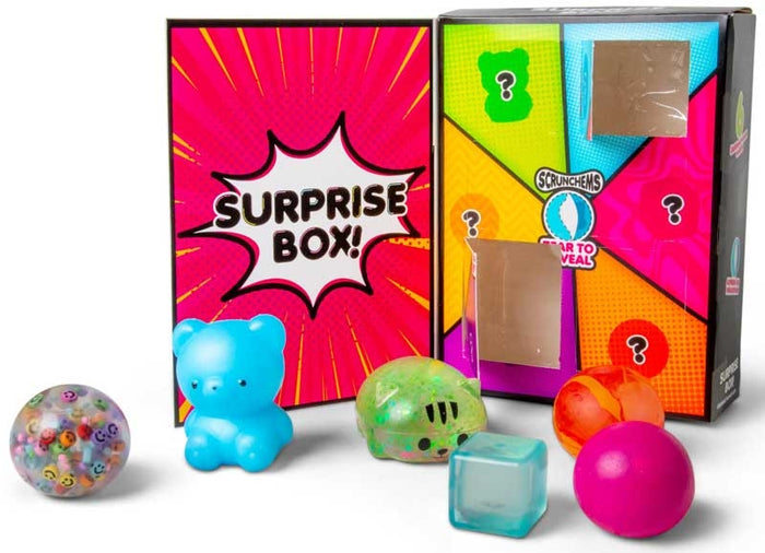 Colorful surprise box featuring a squishy blue bear, green cat, and several textured sensory balls and toys.