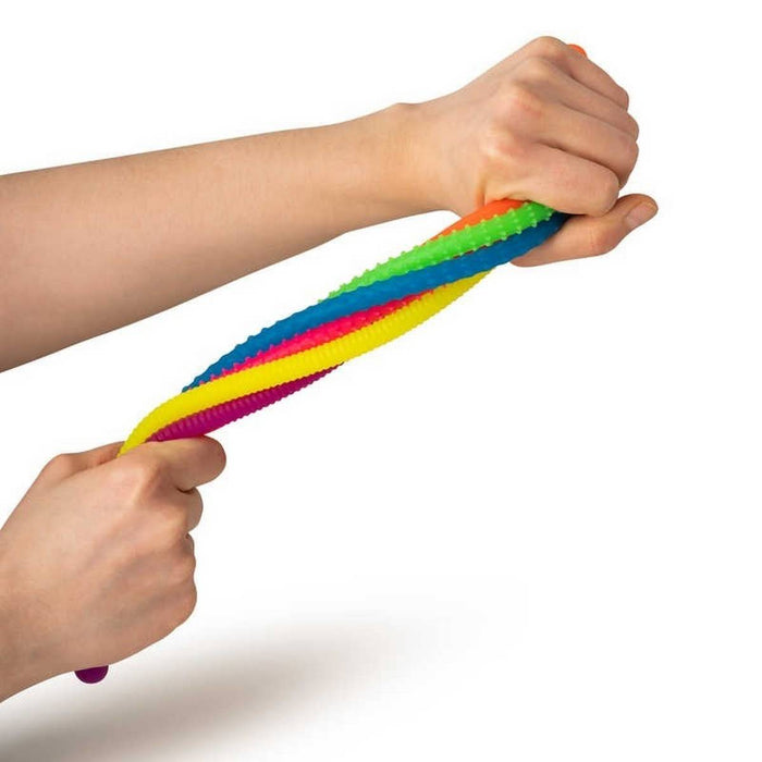 Hands pull and stretch a colorful, bumpy, twisted sensory noodle toy in bright rainbow colors.