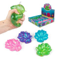 Hand squeezing a green glitter toy next to a retail box and pink, purple, blue, and green textured glitter squishies.