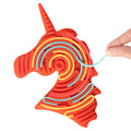 Orange unicorn silicone sensory toy with maze grooves and colorful flexible strings being pressed in by a hand.