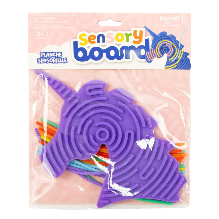 Purple unicorn sensory board with grooved maze pattern and rainbow strings in clear retail packaging.