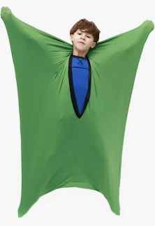 A boy inside a green star-shaped stretchy fabric suit with arms and legs extended and a blue panel on the chest.