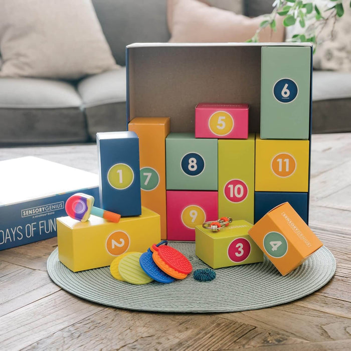 Colorful numbered boxes and sensory fidget toys like textured discs, a pop-it, and a spiky ball on a grey mat.