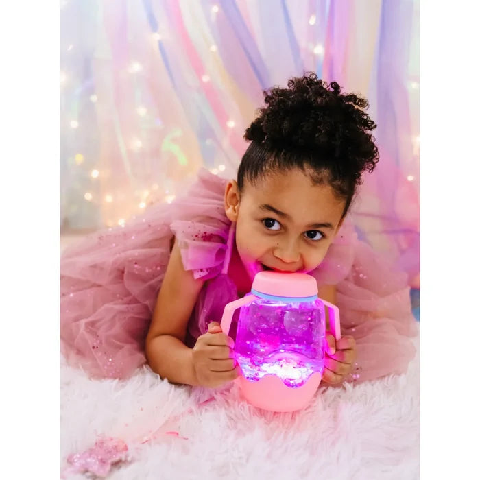 Child holding a pink sensory jar with two handles, glowing with pink light and internal sparkles.