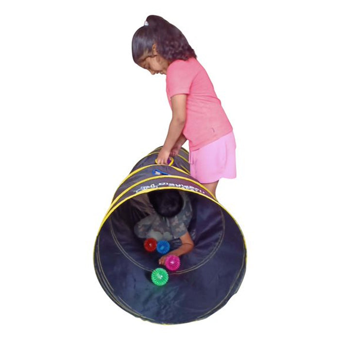 Girl in pink stands over a blue and yellow pop-up tunnel while a child crawls inside with four glowing LED balls.