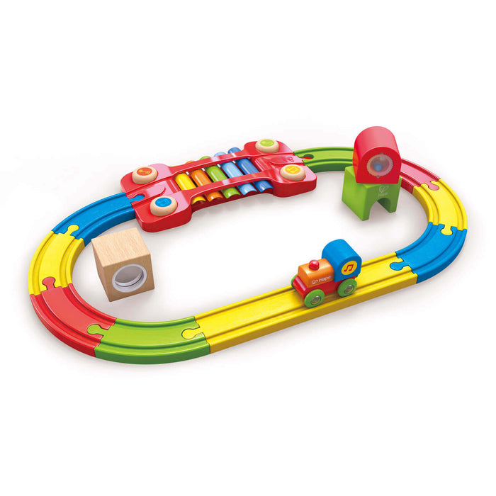 Oval rainbow wooden train track featuring a xylophone bridge, sensory blocks, and a small toy engine.