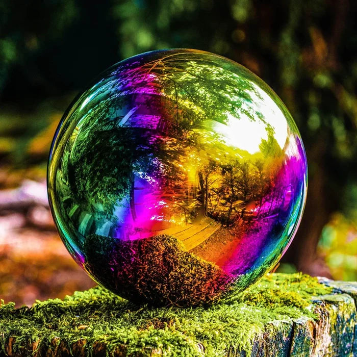 A shiny iridescent ball on a mossy log, reflecting a forest scene in vibrant rainbow colors.