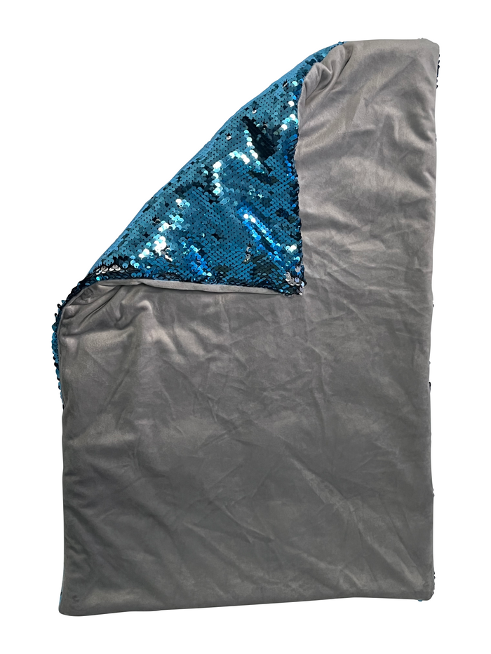 Rectangular weighted lap pad with blue sequins on one side and soft grey fabric on the other, partially folded.