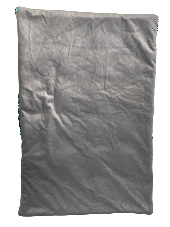 Rectangular dark grey fabric lap pad with a wrinkled texture and blue sequins visible along the side edges.
