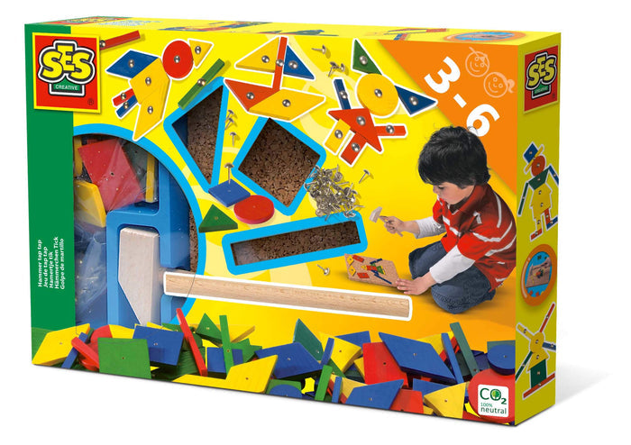 Bright yellow toy box showing colorful wooden shapes, a hammer, and a boy pinning designs onto a cork board.