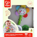 Colorful Hape flower rattle in packaging with a smiley face, textured petals, and a photo of a baby playing.