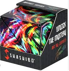 A black Shashibo box containing a puzzle cube with a vibrant, swirling neon rainbow paint pattern.