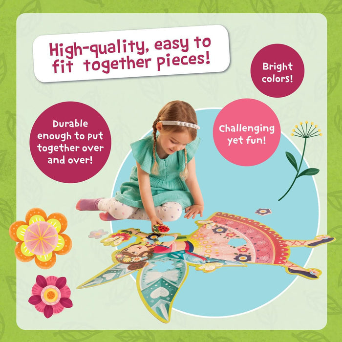 Young girl assembling a large, colorful fairy-shaped floor puzzle featuring bright patterns and shimmery details.