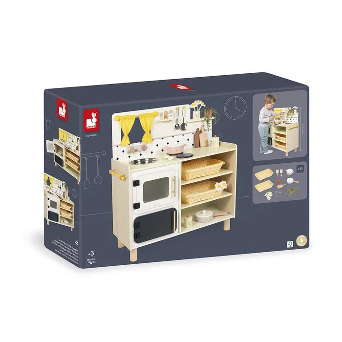 Dark blue box showing a light-wood play kitchen with yellow curtains, oven, storage baskets, and toy accessories.