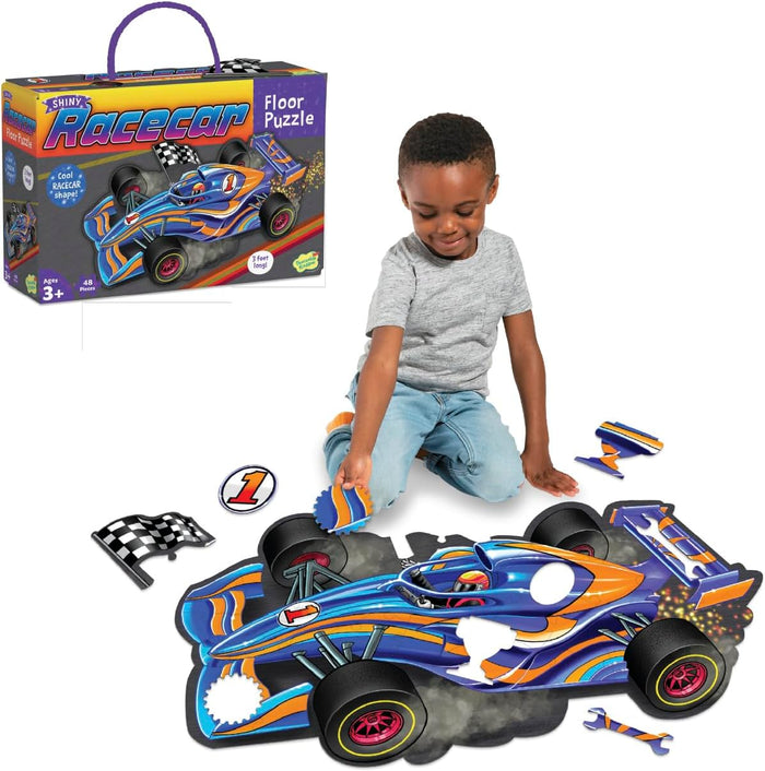 Child building a large blue and orange racecar shaped floor puzzle with its product box shown.