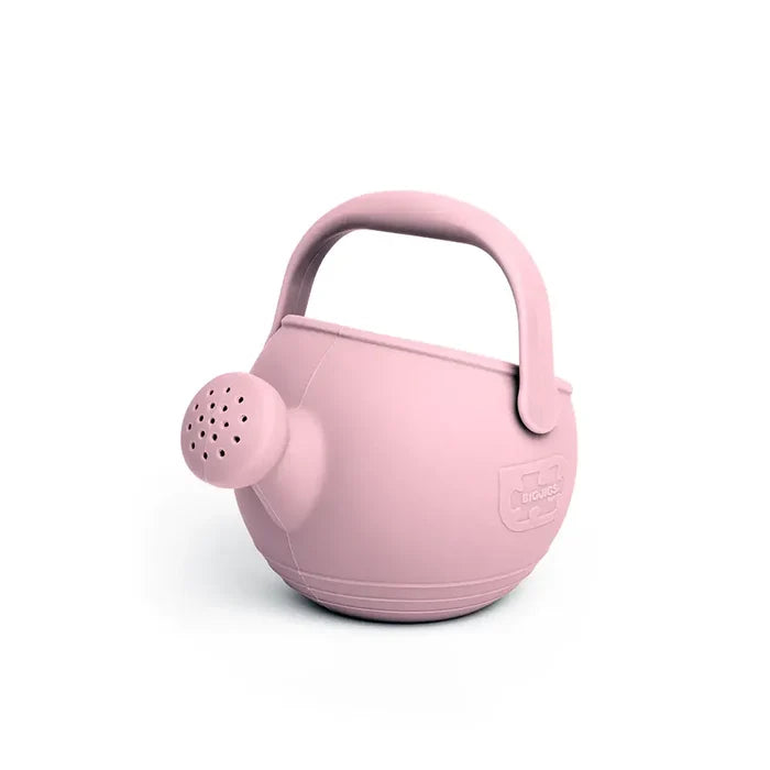 Light pink silicone watering can with a round body, large arched handle, and rose spout for kids' play.