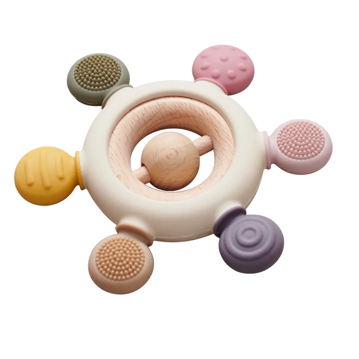 Circular baby teether with a wooden ring center and six textured silicone knobs in muted earth tones.
