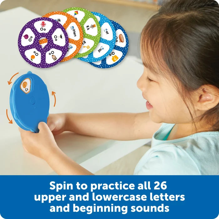 Child spins a blue wheel to reveal letters and pictures, with colorful alphabet discs displayed above.
