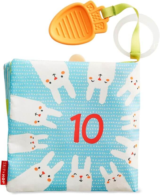 Soft blue fabric book with 10 white bunnies, a red 10, an orange carrot teether, and a clear hanging ring.
