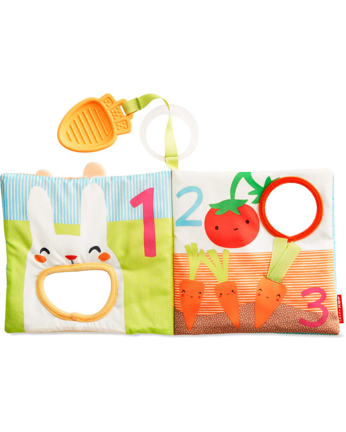 Colorful soft book with a bunny, numbers 1-3, garden vegetables, mirrors, and a hanging orange leaf teether.