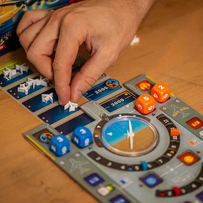 Hand placing a white airplane marker on a board game with blue and orange dice and flight instrument graphics.