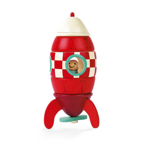 Red and white wooden toy rocket with a checkered middle, three fins, and a smiling pilot inside a round window.