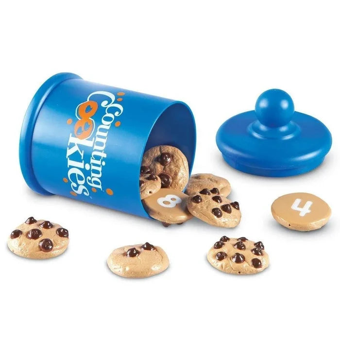Blue toy cookie jar tipped over with plastic chocolate chip cookies spilling out, showing chips and numbers.