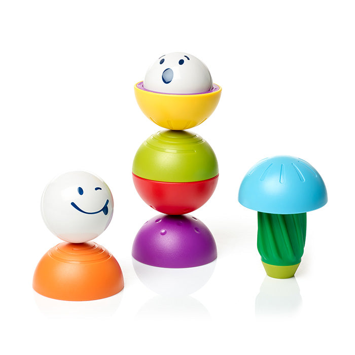 Magnetic toy set featuring white balls with faces, colorful stacking spheres, and a blue mushroom-shaped piece.