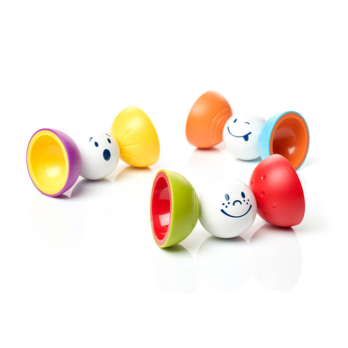 Three magnetic barbell toys with expressive white faces and colorful bowl-shaped ends on a white surface.