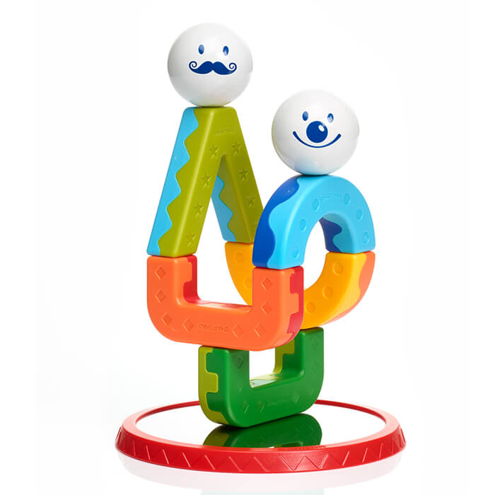 Colorful magnetic blocks stacked into two figures with white ball heads and blue faces on a red mirrored base.