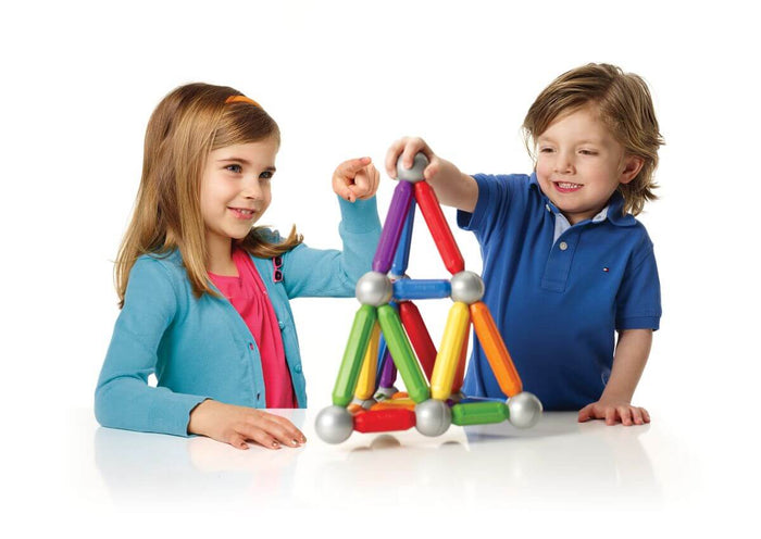 Boy and girl building a pyramid structure with large colorful magnetic rods and silver connecting spheres.
