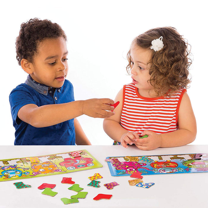 Two children match colorful patterned boot pieces to monster-themed game boards on a white table.