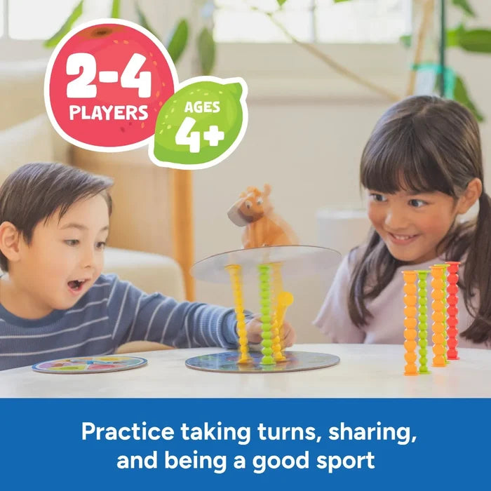 Two children balancing a capybara figure on a disc with colorful, segmented poles. Icons show 2-4 players and ages 4+.