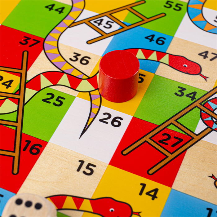 Bright wooden game board with numbered squares, ladders, colorful snakes, and a red cylindrical playing piece.