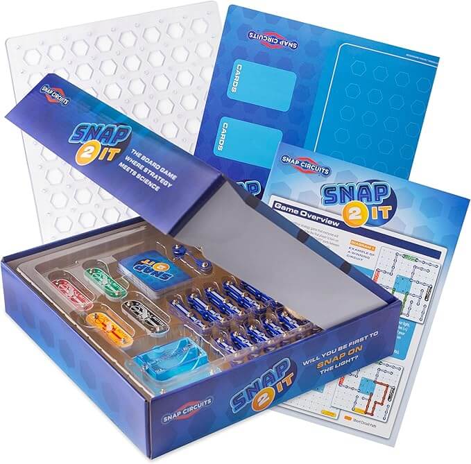 Open blue Snap 2 It game box with colorful circuit components, a white hexagonal grid board, and instruction manuals.