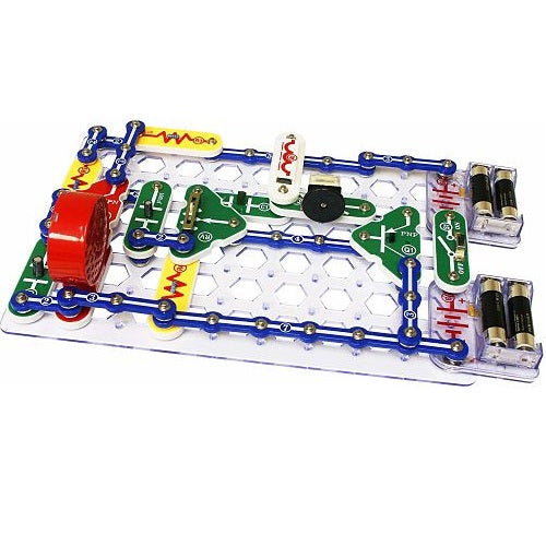 Toy electronic circuit with blue snap wires, green parts, and a red speaker on a clear plastic grid base.