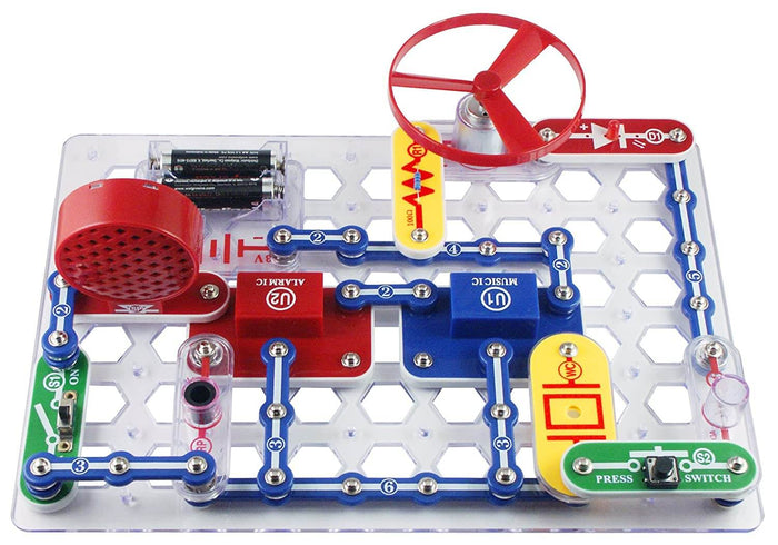 Snap-together electronic circuit on a clear grid board with a red fan, speaker, battery pack, and colorful modules.