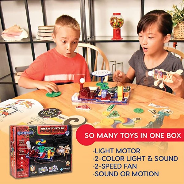 Two kids build colorful projects with a Snap Circuits Motion kit; product box and a toy airplane are visible.