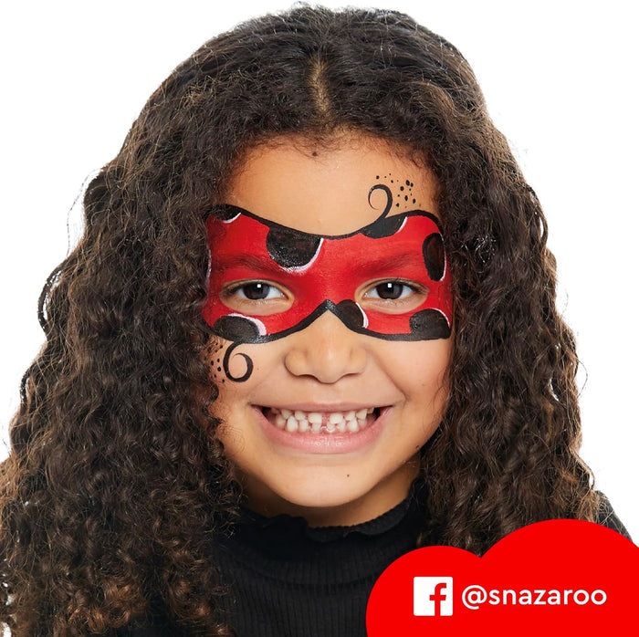 Smiling girl with a red and black ladybug-themed face paint mask and decorative black swirls.