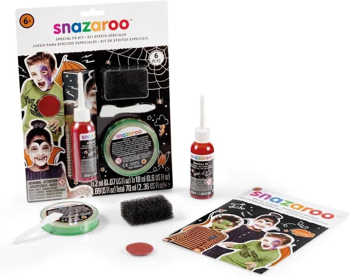 Halloween makeup kit with red fake blood, green paint, skin wax, sponges, and a guide showing painted child characters.