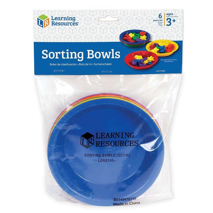 Six rainbow-colored, round plastic bowls stacked inside a clear retail bag with a brand header.