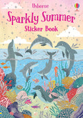 Pink sparkly book cover with grey dolphins leaping and swimming in a blue ocean above a vibrant coral reef with fish.