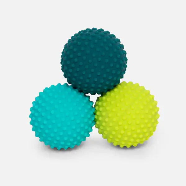 Three nubby silicone spheres in teal, turquoise, and lime green, stacked in a pyramid.