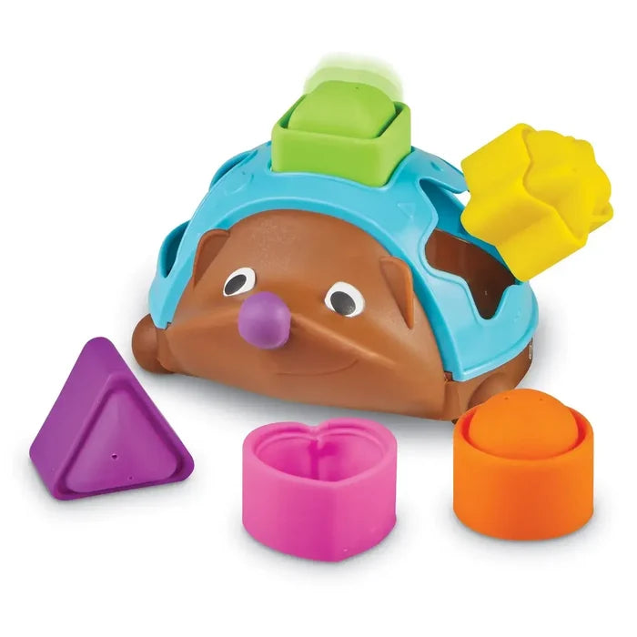Brown toy hedgehog with blue shell and five colorful shape pieces: triangle, heart, circle, star, and square.