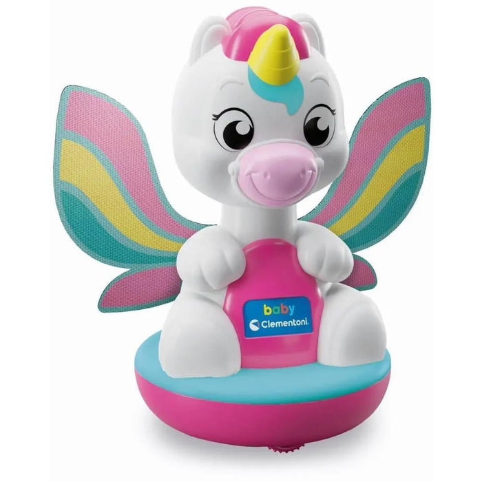 White baby unicorn toy with large rainbow wings, yellow horn, and pink snout on a pink and teal rounded base.