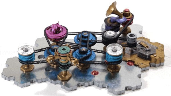 Intricate mechanical toy with blue, purple, and brass gears connected by black belts on a metallic silver base.