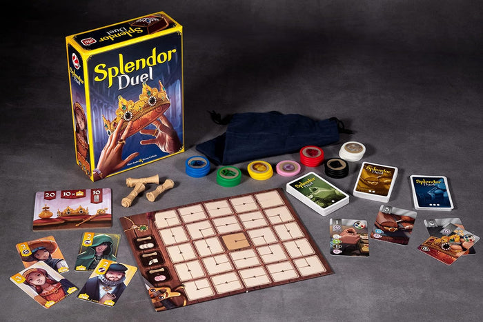 Splendor Duel board game box with jeweled crown art, cards, colorful tokens, and a grid board on a gray surface.
